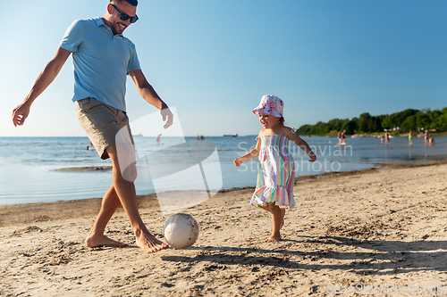 Image of happy father and daughter playing ball on beach