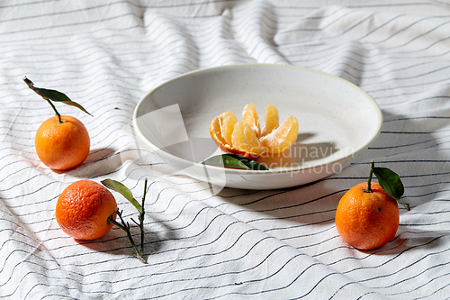 Image of still life with mandarins on plate over drapery