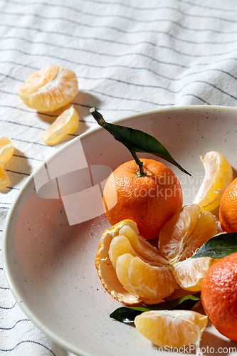 Image of still life with mandarins on plate over drapery