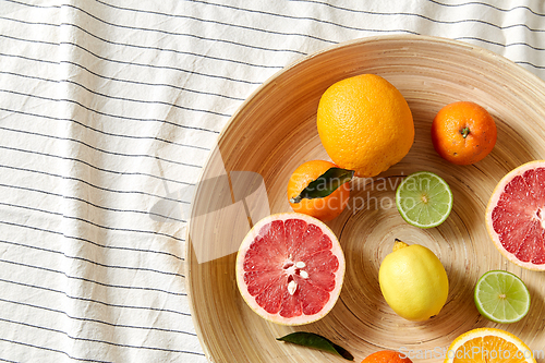 Image of close up of citrus fruits on wooden plate