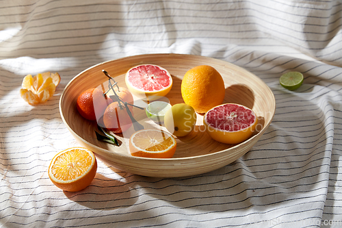 Image of close up of citrus fruits on wooden plate