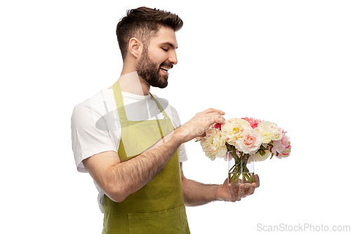 Image of smiling male gardener with bunch of peony flowers