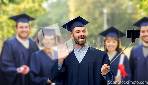 Image of male graduate student with smartphone takes selfie