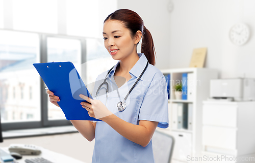 Image of asian female doctor with clipboard at hospital