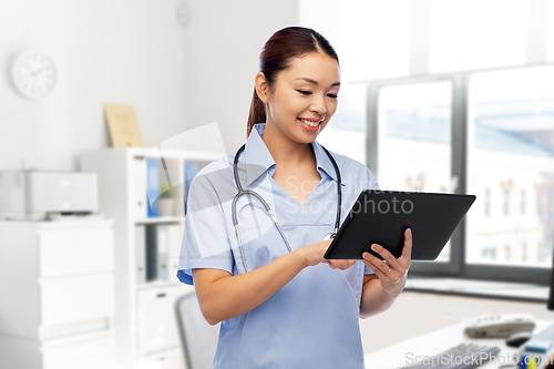 Image of asian female nurse with tablet pc at hospital