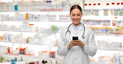 Image of happy smiling female doctor with smartphone