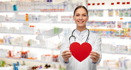 Image of smiling female doctor with heart and stethoscope