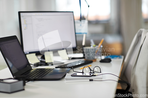 Image of laptop computer and gadgets on table at office