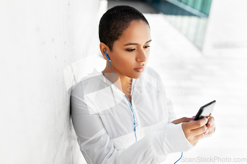 Image of african american woman with earphones and phone