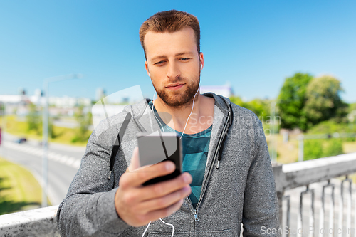 Image of young man with earphones and smartphone