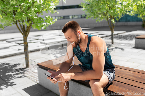 Image of young athlete man with earphones and smartphone