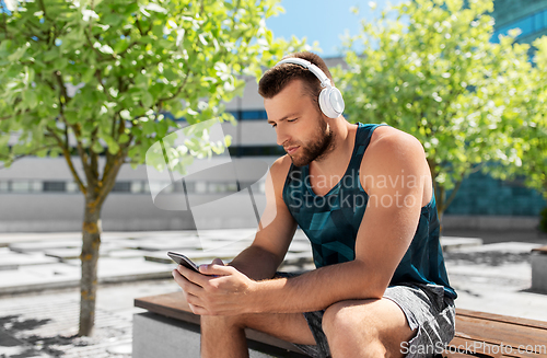 Image of young athlete man with headphones and smartphone