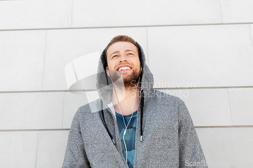 Image of man in earphones listening to music outdoors