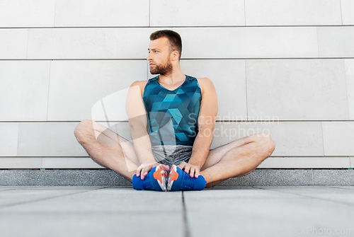 Image of man doing sports and stretching outdoors