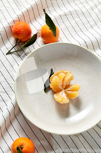 Image of still life with mandarins on plate over drapery