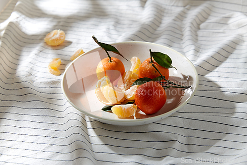 Image of still life with mandarins on plate over drapery