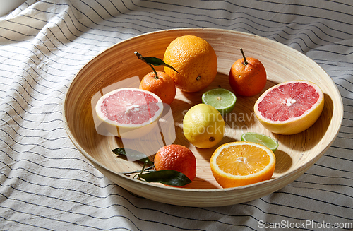 Image of close up of citrus fruits on wooden plate