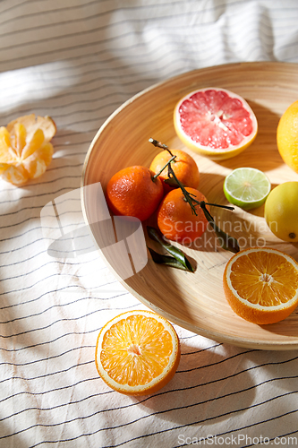 Image of close up of citrus fruits on wooden plate