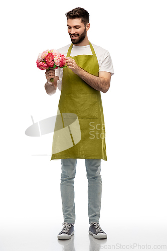 Image of smiling male gardener with bunch of peony flowers