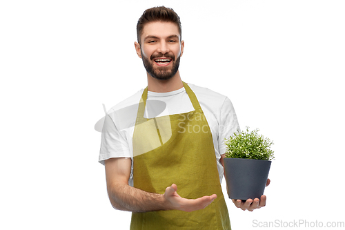 Image of happy smiling male gardener with flower in pot