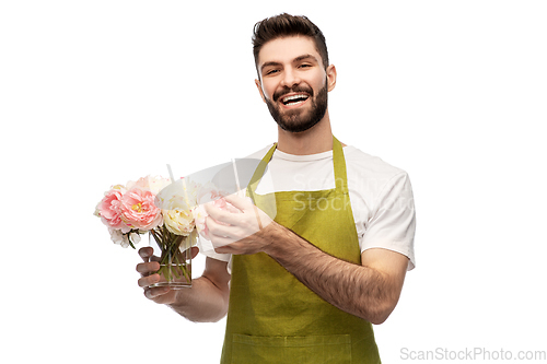 Image of smiling male gardener with bunch of peony flowers