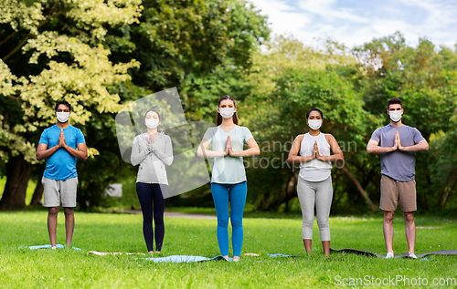 Image of group of people doing yoga at summer park