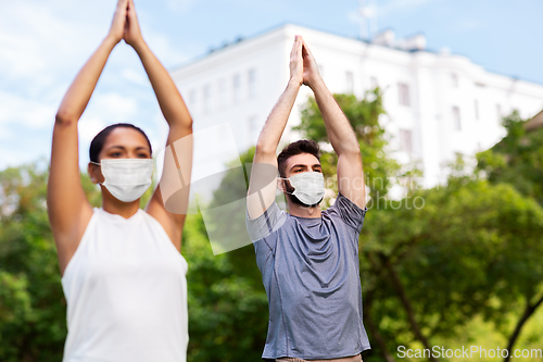 Image of group of people doing yoga at summer park