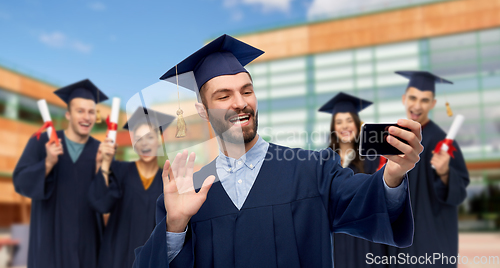 Image of male graduate student with smartphone takes selfie