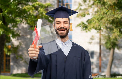 Image of male graduate student in mortar board with diploma