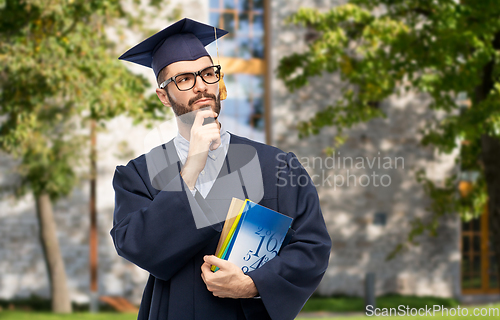 Image of thoughtful graduate student or bachelor with books