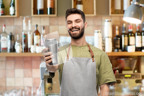 Image of happy waiter with tumbler or takeaway thermo cup