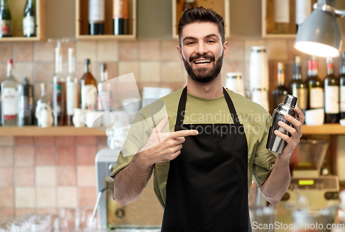 Image of happy barman with shaker preparing