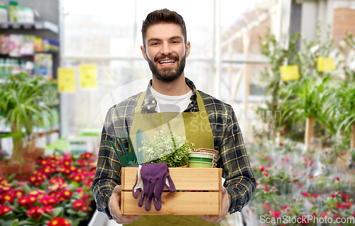 Image of happy gardener or seller with box of garden tools