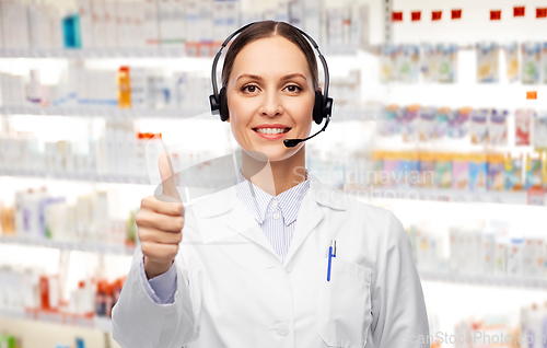 Image of smiling female doctor with headset at pharmacy