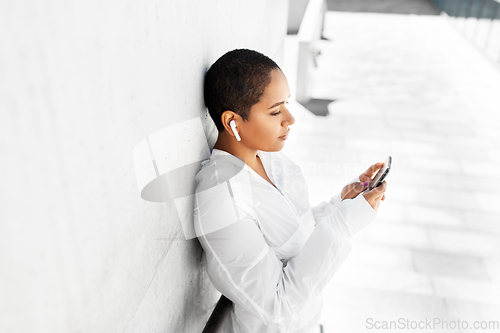 Image of african american woman with earphones and phone