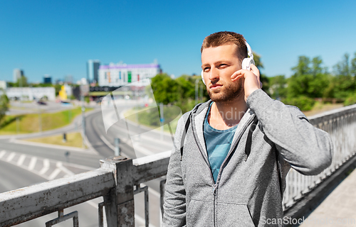 Image of man in headphones listening to music outdoors