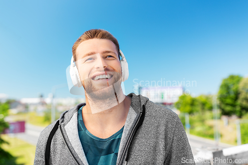 Image of man in headphones listening to music outdoors