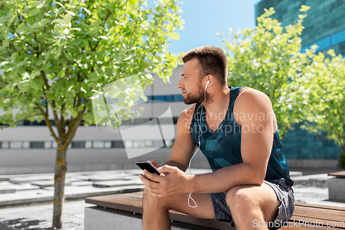 Image of young athlete man with earphones and smartphone