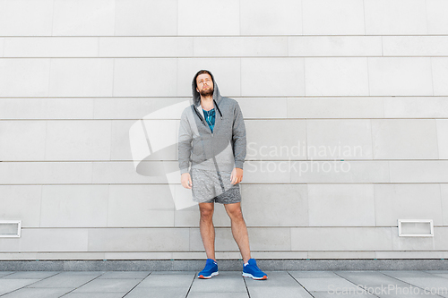 Image of man in earphones listening to music outdoors