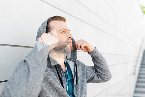 Image of man in earphones listening to music outdoors