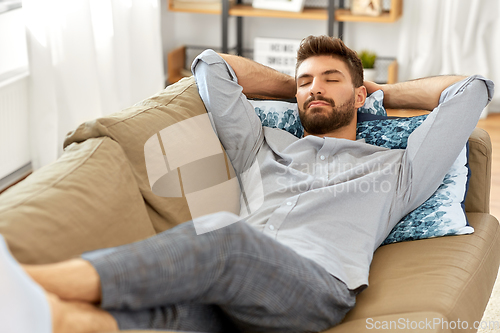 Image of young man sleeping on sofa at home