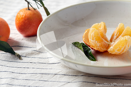 Image of still life with mandarins on plate over drapery