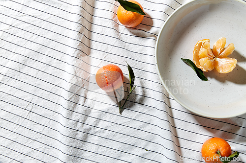 Image of still life with mandarins on plate over drapery