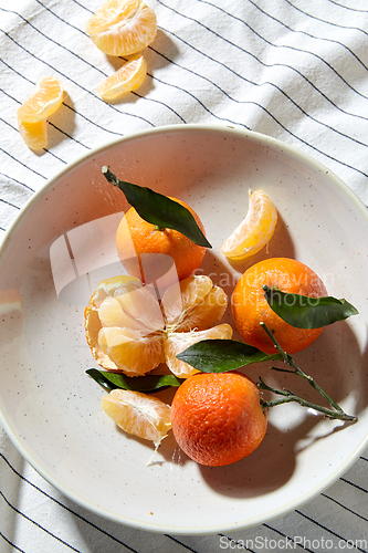 Image of still life with mandarins on plate over drapery