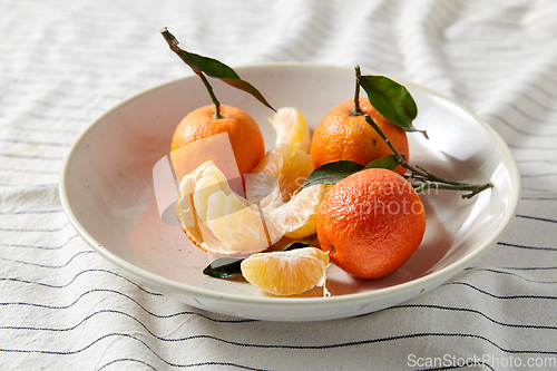 Image of still life with mandarins on plate over drapery