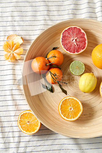 Image of close up of citrus fruits on wooden plate