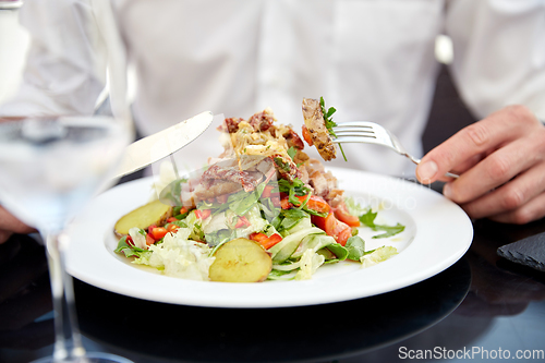 Image of close up of man eating food at restaurant