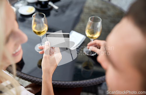 Image of close up of couple with credit card and bill at restaurant