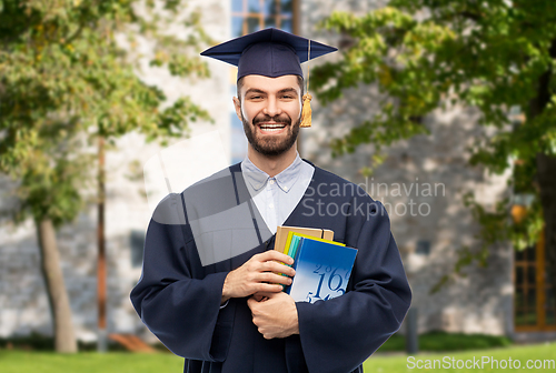 Image of happy graduate student or bachelor with books