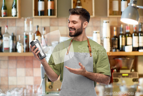 Image of happy waiter with tumbler or takeaway thermo cup